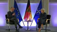 Verteidigungsministerin Christine Lambrecht sitzt auf einer Bühne ihrem Gesprächspartner gegenüber.