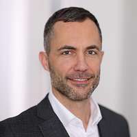Der Pressesprecher des BMVG, Michael Stempfle, schaut in die Kamera für eine Portraitaufnahme.