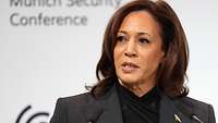 Kamala Harris steht an einem Rednerpult und spricht in das Mikrofon