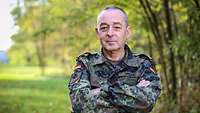Generalinspekteur Breuer steht in einem wäldlichem Gebiet und posiert für eine Portrait Aufnahme.