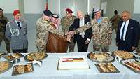 Gemeinsam schneiden deutsche Soldaten und Zivilisten aus Beirut einen Kuchen zur symbolischen Einweihung an.