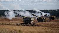 Drei Panzerhaubitzen 2000 führen ein Gefechtsschießen durch.