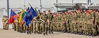 Mehrere Soldaten stehen in Formation zum Antreten eines Appells. Vor Ihnen Soldaten die maschieren.