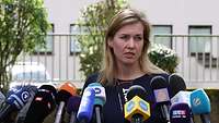 Staatsekretärin Möller steht an einem Pult mit Mikrofonen