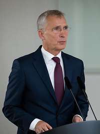 Jens Stoltenberg steht an einem Rednerpult und spricht.