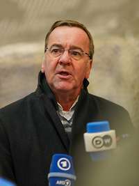 Boris Pistorius steht vor Mikrofonen der öffentlichen Presse und spricht.