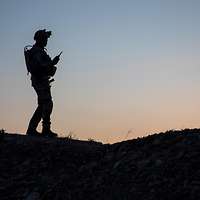 Vor Abendhimmel zeichnet sich die Silhouette eines Soldaten ab.