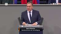 Der Verteidigungsminister steht hinter einem Rednerpult
