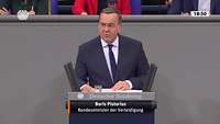 Der Verteidigungsminister steht hinter einem Rednerpult