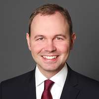 Portrait eines Mannes im Anzug mit weinroter Krawatte