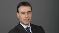 Nils Schmidt schaut für eine Portraitaufnahme in die Kamera.