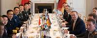 Admiral Dong Jun und Boris Pistorius sitzen sich mit ihren Delegationen am Tisch gegenüber.