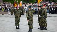 Zwei Soldaten salutieren sich im Zuge einer Militärparade.