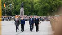Boris Pistorius, Friedrich Merz, Gitanas Nausėda and Dovilė Šakalienė are walking together in front of Soldiers.