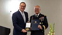 Boris Pistorius und SACEUR General Cavolis halten gemeinsam die Manfred Wörner Medaille und eine Urkunde zum Betrachter.