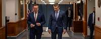 Boris Pistorius und Pete Hegseth laufen nebeneinander durch einen Gang auf den Betrachter zu.