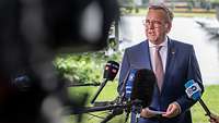 Boris Pistorius steht vor Medienvertretern und hält ein Statement ab.
