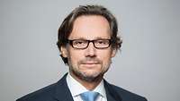 Jens Plötner is looking at the camera for a portrait photo.