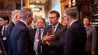 Dr. Nils Schmid und Dr. Cornelius Zimmermann, sowie weitere Personen unterhalten sich.