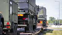 Mehrere Militärfahrzeuge stehen hintereinander zum Transport