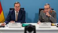 Boris Pistorius und Generalinspekteur Carsten Breuer sitzen nebeneinander an einem Tisch.