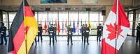 Die kanadische und deutsche Fahne stehen nebeneinander in einem Foyer.