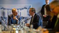 Boris Pistorius und Friedrich Merz sitzen an einem Tisch und sprechen miteinander