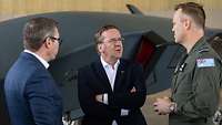 Minister Pistorius unterhält sich mit zwei anderen Männern, einer davon trägt Uniform. 