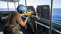 Eine Soldatin schießt mit dem MG5 von Bord der Fregatte Brandenburg während der UN-Mission UNIFIL.