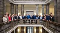 Alle Angehörigen des Bundeskabinetts stehen nebeneinander in der Säulenhalle des Verteidigungsministeriums.