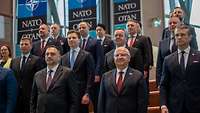 Mehrere Teilnehmer des NATO-Gipfels stehen nebeneinander