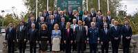 Mehrere Personen stehen für ein Gruppenfoto zusammen. Die Flaggen von Irland und Europa wehen an Masten.