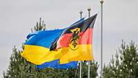 Die Bundesdienstflagge weht zusammen mit der ukrainischen Flagge, dahinter die Flagge der EU.
