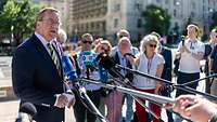 Boris Pistorius spricht in die Mikrofone der Presse. Hinter ihm stehen mehrere Personen.