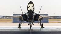 Ein Kampfflugzeug vom Typ F-35A steht mit offenem Cockpit in einem Hangar.