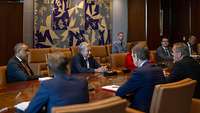 Boris Pistorius und António Guterres sitzen zusammen mit weiteren Personen an einem Tisch.