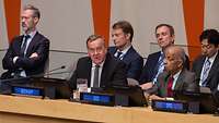 Boris Pistorius sitzt mit anderen Personen an einem Tisch bei einer Konferenz.