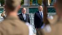 Boris Pistorius und Romulusz Ruszin-Szendi stehen nebeneinander und verfolgen die Ehrenformation.