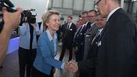 Von der Leyen schüttelt einem Mann die Hand