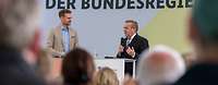 Verteidigungsminister Pistorius und eine weitere Person stehen auf einer Bühne.