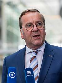 Boris Pistorius spricht in zwei Mikrofone