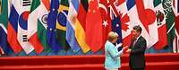 Xi Jinping und Merkel im Gespräch, im Hintergrund Plakat zum G20-Gipfel