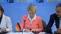 Von der Leyen unterzeichnet ein Dokument 