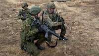 Ein deutscher Soldat und litauischer Soldat im Gelände