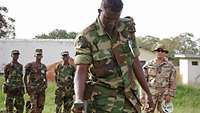 Somalischer Soldat mit Metalldetektor, im Hintergrund weitere Soldaten