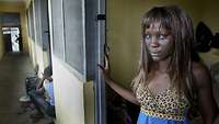 Frau aus Nigeria steht im Türrahmen ihres Apartments
